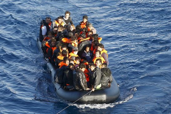 A dinghy of refugees and migrants is towed by a Turkish Coast Guard fast rigid-hulled inflatable boat on the Turkish territorial waters of the North Aegean Sea