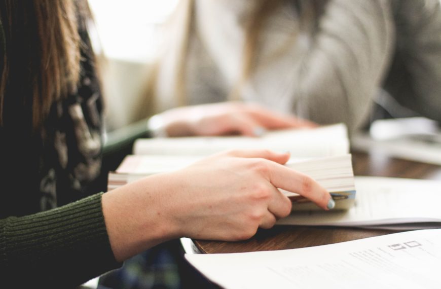 woman sitting on chair in front of table white reading book