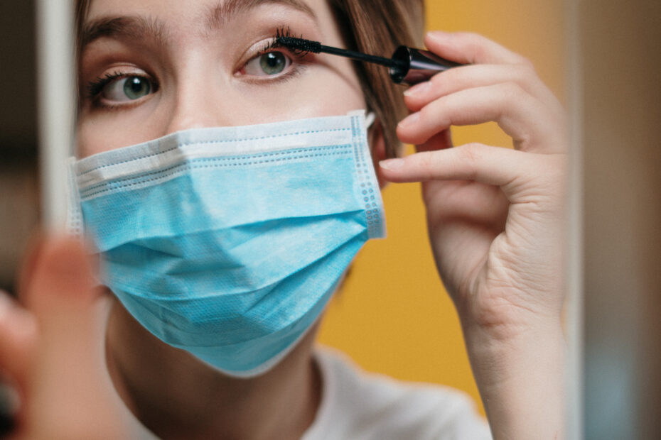 Woman putting on mascara despite the outbreak