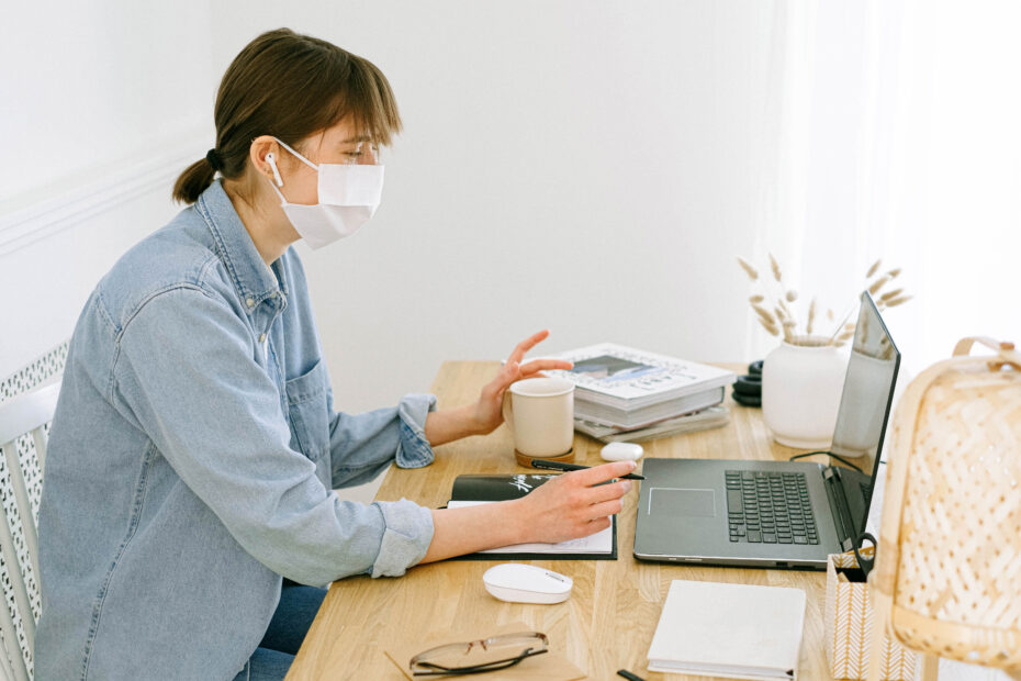 Woman with face mask looking at a laptop