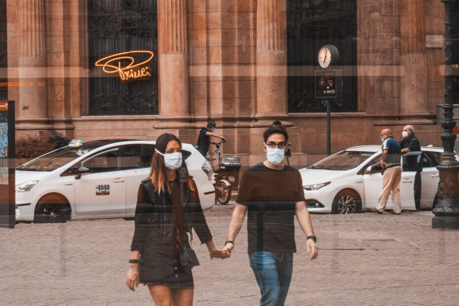 man in black t-shirt and blue denim jeans standing beside woman in black jacket